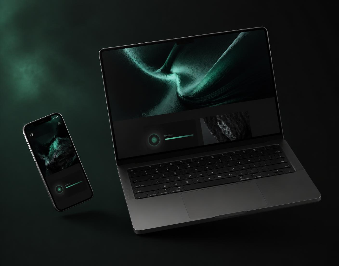 A laptop and phone showing a dark, emerald-accented website design